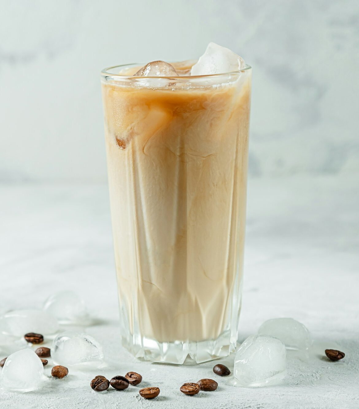 Refreshing cold Greek coffee frappe on gray stone background. Copy space